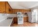 This is a kitchen with traditional wood cabinets and white appliances at 34 Scotts Creek Run, Angier, NC 27501