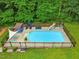 Aerial view of a swimming pool with a slide, sunshades, and a lush backyard at 3421 Kistler Ct, Willow Springs, NC 27592