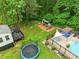 Large backyard with a playset, trampoline, deck, and above ground pool with lounge chairs at 3421 Kistler Ct, Willow Springs, NC 27592