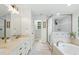 Luxurious bathroom featuring double vanities, soaking tub, glass-enclosed shower, and stylish finishes at 3421 Kistler Ct, Willow Springs, NC 27592