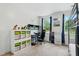 Bedroom with a lofted bed over a desk, a toy shelf, and windows with bright patterned curtains at 3421 Kistler Ct, Willow Springs, NC 27592