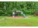Backyard playground with a slide, swing set and play structure on a well-manicured lawn at 3421 Kistler Ct, Willow Springs, NC 27592