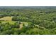 Expansive aerial view of a property nestled amidst lush green trees and a verdant landscape at 4053 Friendship Patterson Mill Road, Burlington, NC 27215