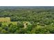 Lush aerial view of a house situated on sprawling grounds surrounded by a dense, verdant forest at 4053 Friendship Patterson Mill Road, Burlington, NC 27215