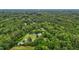 Scenic aerial view showcases a lush forest and a charming home with a long driveway leading to the residence at 4053 Friendship Patterson Mill Road, Burlington, NC 27215