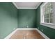 Bedroom with green walls, a window, and trim in need of flooring at 4053 Friendship Patterson Mill Road, Burlington, NC 27215