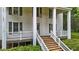 Close-up view of the front entrance, showcasing wooden steps, white railings, and green shutters at 4053 Friendship Patterson Mill Road, Burlington, NC 27215