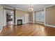 Classic living room with hardwood floors, fireplace, chandelier and natural light streaming through shuttered windows at 4053 Friendship Patterson Mill Road, Burlington, NC 27215