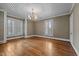 Bright living room with hardwood floors, fireplace, shuttered windows, and classic chandelier at 4053 Friendship Patterson Mill Road, Burlington, NC 27215
