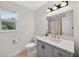 This bathroom offers a sink with vanity, modern lighting, wood-style flooring, and a window for natural light at 4067 Williams Mill Rd, Burlington, NC 27215