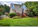 Charming two-story house with blue metal roof, inviting backyard with wooden deck, and lush landscaping at 4067 Williams Mill Rd, Burlington, NC 27215
