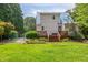 Charming two-story house with blue metal roof, inviting backyard with wooden deck, and lush landscaping at 4067 Williams Mill Rd, Burlington, NC 27215