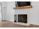 Close-up of a brick fireplace with a wooden mantle and black iron fire screen at 4067 Williams Mill Rd, Burlington, NC 27215