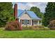 Charming single-Gathering home with a blue metal roof, brick chimney and a landscaped front yard at 4067 Williams Mill Rd, Burlington, NC 27215