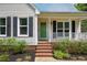 A charming front porch with brick steps and green door leads to the main entrance of the home at 4067 Williams Mill Rd, Burlington, NC 27215