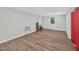 Spacious room features wood-look flooring, multiple windows, and a striking red door, ideal for versatile use at 4067 Williams Mill Rd, Burlington, NC 27215