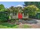 Exterior view of a well-maintained shed with a red door, surrounded by mature trees and landscaping at 4067 Williams Mill Rd, Burlington, NC 27215
