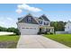 Inviting two-story home featuring a two-car garage and lush green lawn at 414 Fallingbrook Dr, Kenly, NC 27542
