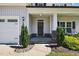 Welcoming front porch with stone accents, a well-manicured garden and walkway to front door at 414 Fallingbrook Dr, Kenly, NC 27542