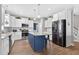 Large, open kitchen features stainless appliances, white cabinets, a blue island, and a subway tile backsplash at 414 Fallingbrook Dr, Kenly, NC 27542