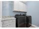 Well-organized laundry area featuring modern black appliances and ample storage space at 414 Fallingbrook Dr, Kenly, NC 27542