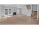 Cozy living room with fireplace, staircase, ceiling fan, and access to the outdoors at 4406 Still Pines Dr, Raleigh, NC 27613
