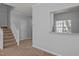 View of the staircase and pass-through window to the kitchen with granite countertop and stainless steel faucet at 4406 Still Pines Dr, Raleigh, NC 27613