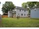 Spacious backyard showcases the home's exterior, surrounded by green grass and trees at 4511 Denfield St, Durham, NC 27704