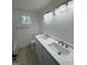 Bathroom with double sink vanity, wood-look flooring and large mirror and ample lighting at 4511 Denfield St, Durham, NC 27704