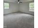 Spacious bedroom features neutral carpet, a ceiling fan, and two windows at 4511 Denfield St, Durham, NC 27704