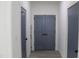 Hallway with multiple blue painted doors, gray floors and white trim at 4511 Denfield St, Durham, NC 27704