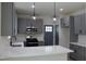 Modern kitchen with gray cabinetry, stainless steel appliances and a spacious island with quartz countertops at 4511 Denfield St, Durham, NC 27704