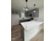 Stylish kitchen featuring gray cabinets, modern pendant lighting and sleek white countertops at 4511 Denfield St, Durham, NC 27704