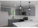 Stylish kitchen featuring gray cabinets, stainless steel appliances and sleek white countertops at 4511 Denfield St, Durham, NC 27704