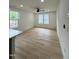 Bright living room featuring light wood floors and large windows with a view of the surrounding landscape at 4511 Denfield St, Durham, NC 27704