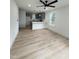 Bright living room featuring light wood floors, ceiling fan, and open access to the contemporary kitchen at 4511 Denfield St, Durham, NC 27704
