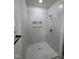 Newly tiled shower with marble-look tile, a rainfall showerhead, and built-in shelving at 4511 Denfield St, Durham, NC 27704