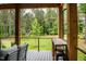 Cozy backyard porch with a built-in table and a view of a tree house in a large backyard at 46 Lakes Edge Ln, Pittsboro, NC 27312