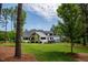 Expansive backyard featuring a modern home, a lush lawn, mature trees, and an inviting outdoor pool area at 46 Lakes Edge Ln, Pittsboro, NC 27312