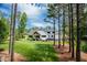 Expansive backyard featuring a white house, a pool area, a porch and mature trees at 46 Lakes Edge Ln, Pittsboro, NC 27312