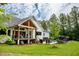 Beautiful backyard with a modern home, covered porch, lush lawn, mature trees, and an inviting outdoor pool area at 46 Lakes Edge Ln, Pittsboro, NC 27312
