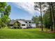 Expansive backyard featuring a modern home, a lush lawn, mature trees, and an inviting outdoor pool area at 46 Lakes Edge Ln, Pittsboro, NC 27312