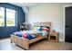 Cheerful bedroom with blue accent wall, hardwood floors, and playful bedding at 46 Lakes Edge Ln, Pittsboro, NC 27312