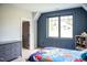 Cozy bedroom with wood floors, blue accent wall, and ample natural light from the window at 46 Lakes Edge Ln, Pittsboro, NC 27312