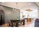 Elegant dining area with custom wall trim, modern chandelier, table, and bench seating, flowing into the kitchen at 46 Lakes Edge Ln, Pittsboro, NC 27312