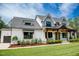 Lovely farmhouse with a lush green lawn, covered porch, and well-manicured landscaping at 46 Lakes Edge Ln, Pittsboro, NC 27312