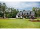 Charming home with a sprawling green lawn, mature trees, and a classic farmhouse style at 46 Lakes Edge Ln, Pittsboro, NC 27312