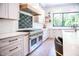 Modern kitchen featuring custom cabinetry, stainless steel appliances, and stylish tile backsplash at 46 Lakes Edge Ln, Pittsboro, NC 27312