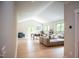 Open concept living room with a large sectional sofa, hardwood floors, and plenty of natural light at 46 Lakes Edge Ln, Pittsboro, NC 27312