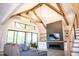 Bright living room with vaulted ceilings, wooden beams, modern fireplace and a large sliding glass door to the patio at 46 Lakes Edge Ln, Pittsboro, NC 27312
